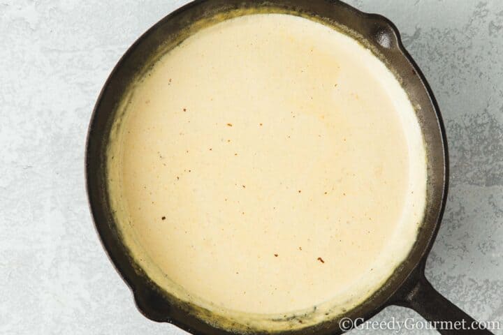 Add cream to sauce in a pan.