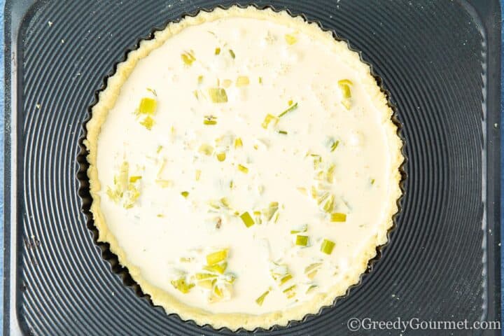 Adding the cream filling to the leek tart.