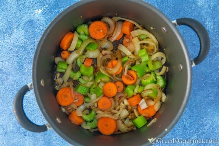 Slowly cooking vegetables in a cooking pot.