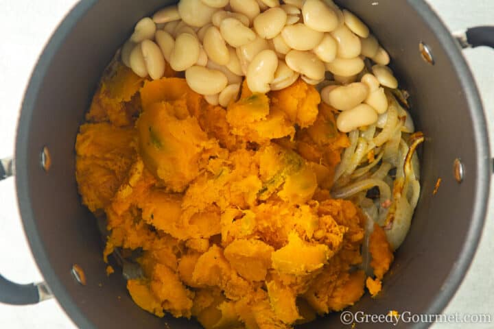 add cooked pumpkin beans to onion pot.