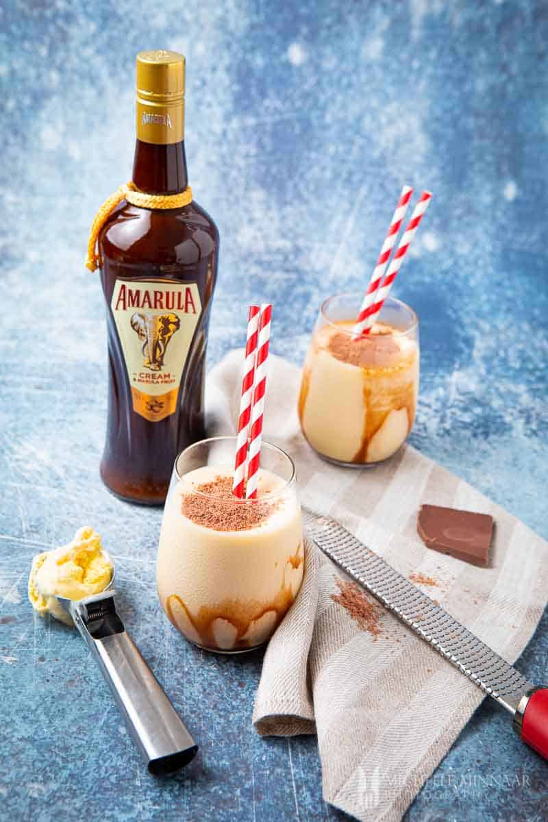 Two glasses of cream don pedro drinks with a bottle of amarula