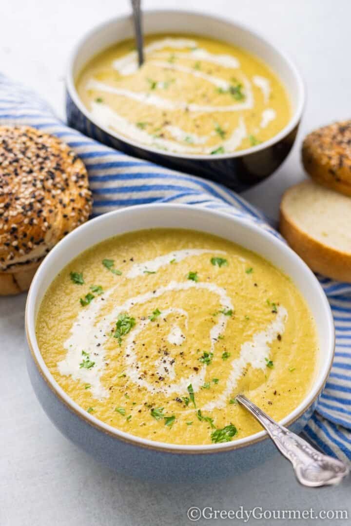 Bowl of chicken carcass soup with slices of bread.