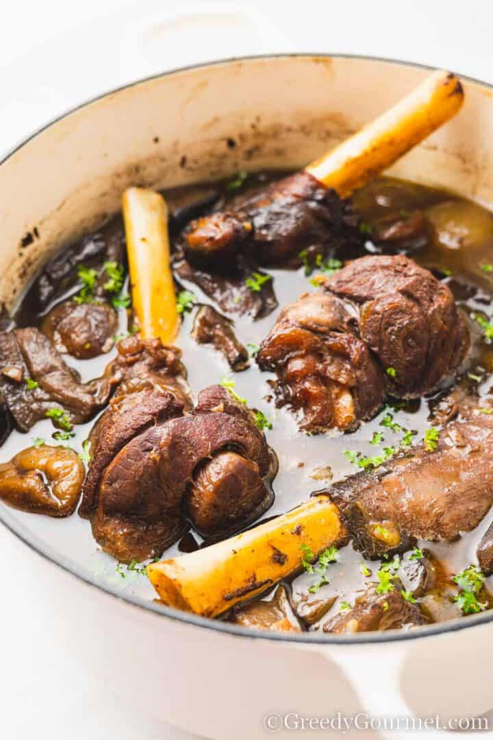 Braised Lamb Shanks with Figs and Eggplant in cooking pot.