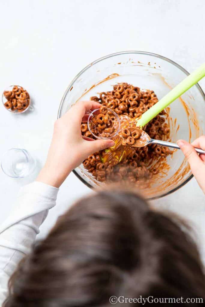 Child make balls of chocolate cheerios 