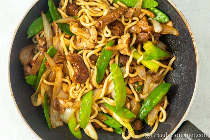 Adding vegetables to wok.