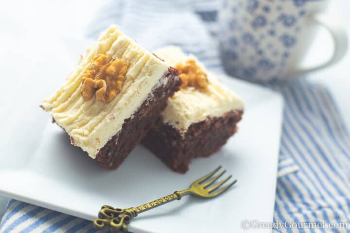 slices of chocolate courgette cake with buttercream icing and a dessert fork.