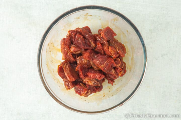 marinating rump steak in a glass bowl.