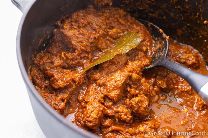 Beef Pastitsada cooking in a pot.