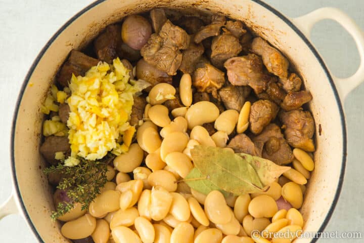 lamb, beans bay and lemon in a pot.