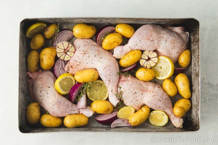 raw chicken with lemons and potatoes traybake.