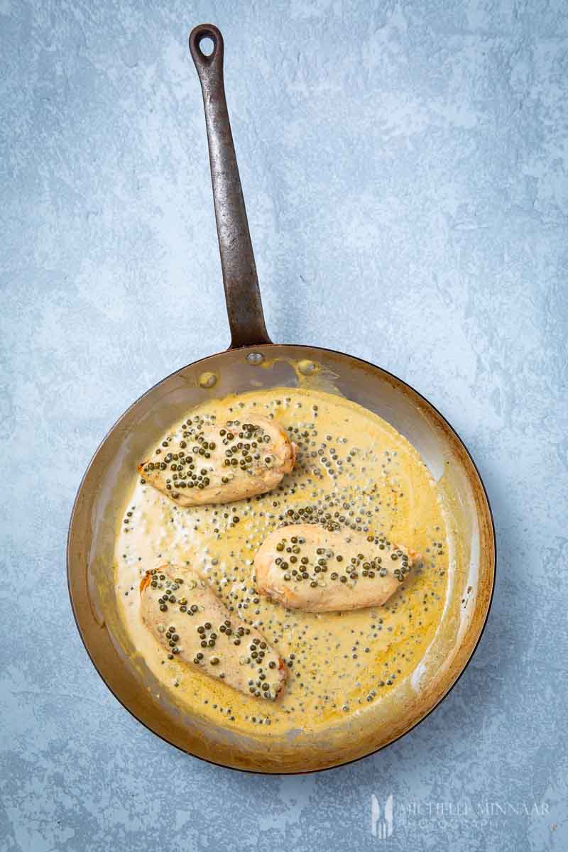 An aerial view of peppercorn chicken in a saute pan 