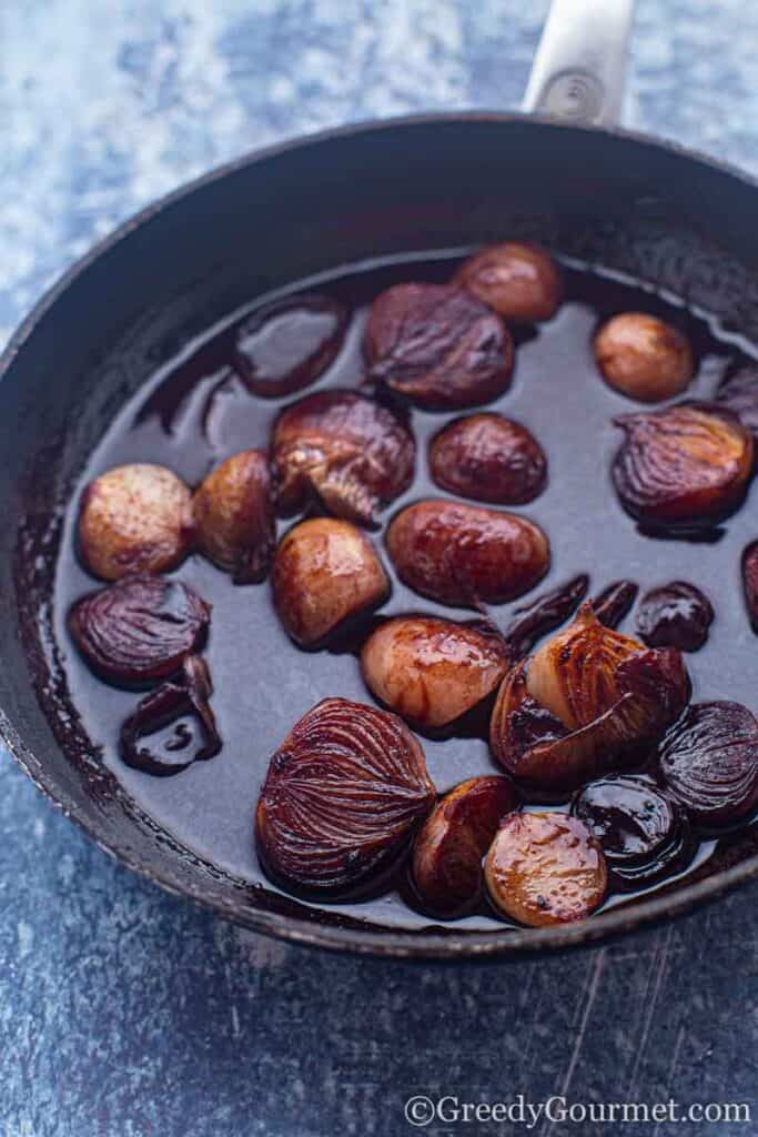 Shallots being fried in a pan 