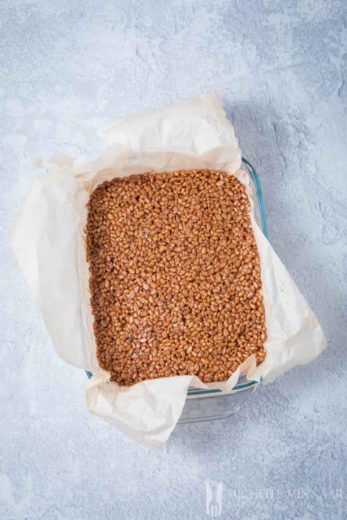 Packed chocolate rice krispies in a baking pan 