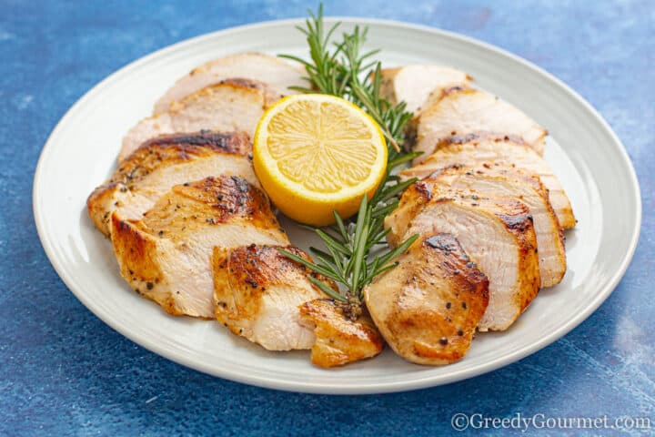 cooked sous vide chicken breast served with lemon and and herbs.