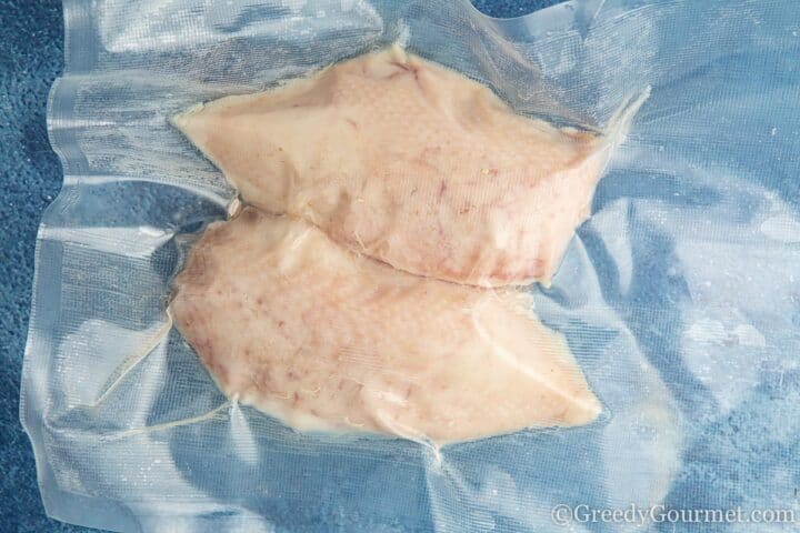cooked vacuumed chicken breast with skin on.