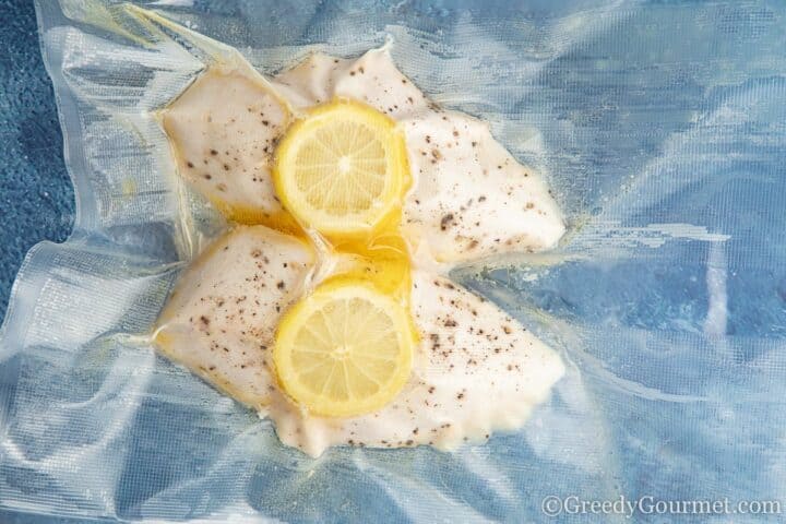 cooked vacuumed chicken breast with a slice of lemon.