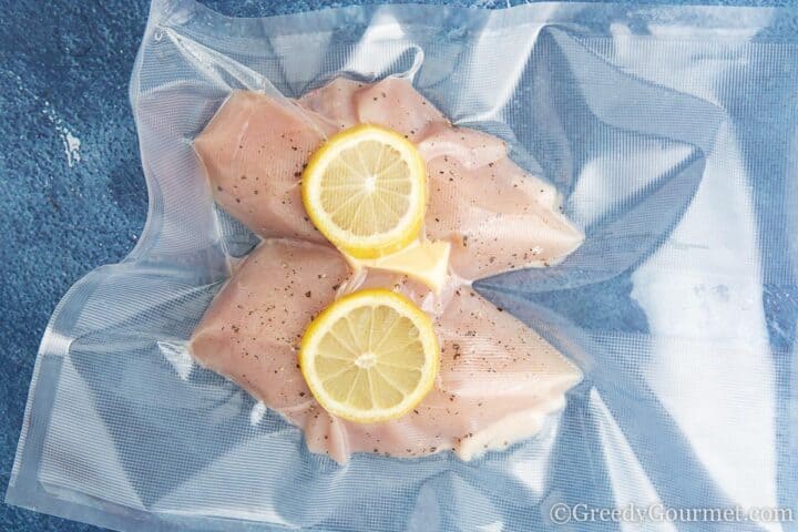 vacuumed skinless chicken breasts with a slice of lemon.