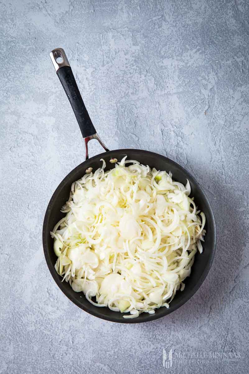 Sliced onions in a saute pan