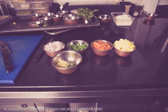 Bowlfuls of onion, ginger, carrot, potato and peas