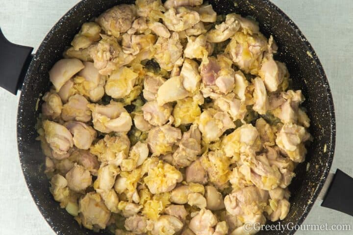 browning chicken thighs in a frying pan.