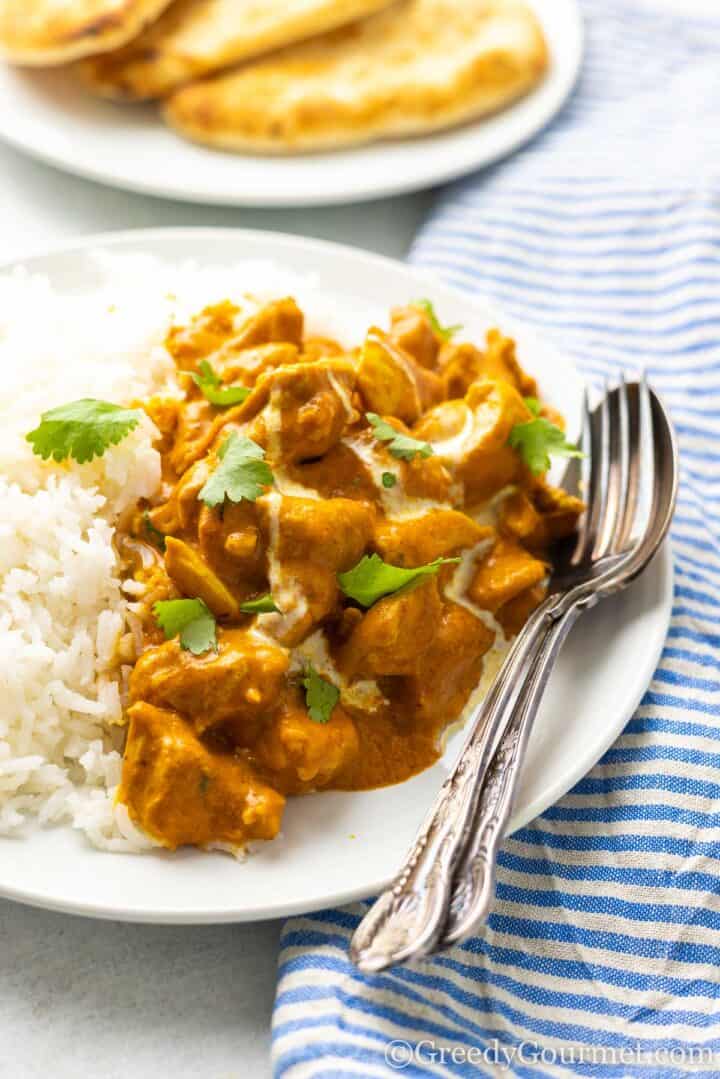 easy chicken curry served with rice on a white plate.