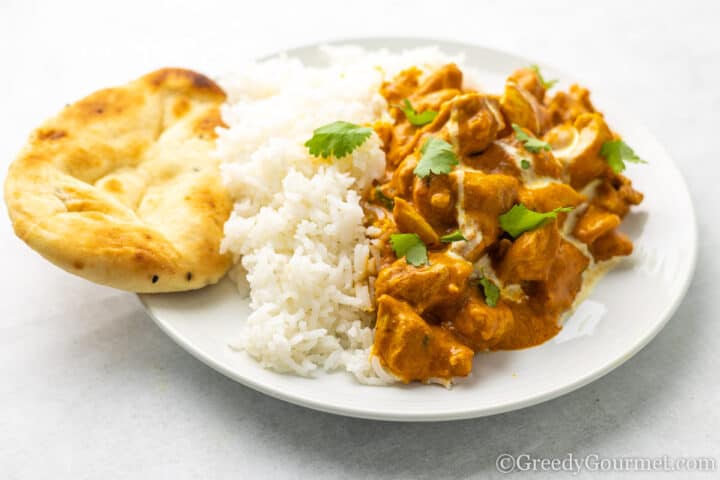 easy chicken curry served with rice on a white plate.