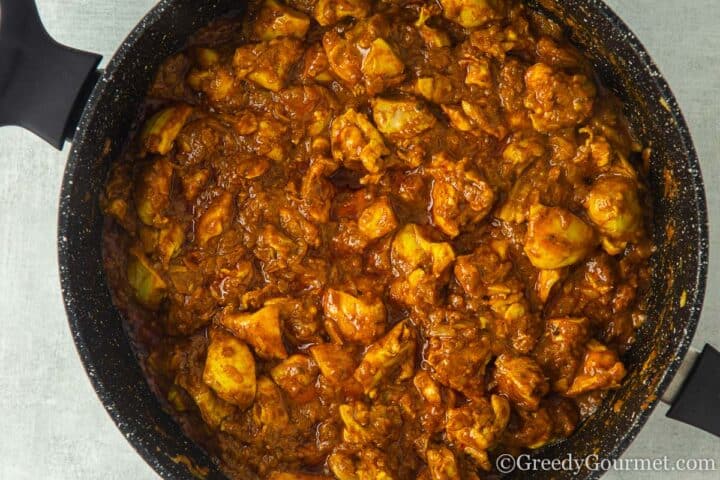 frying curry paste with chicken thighs.