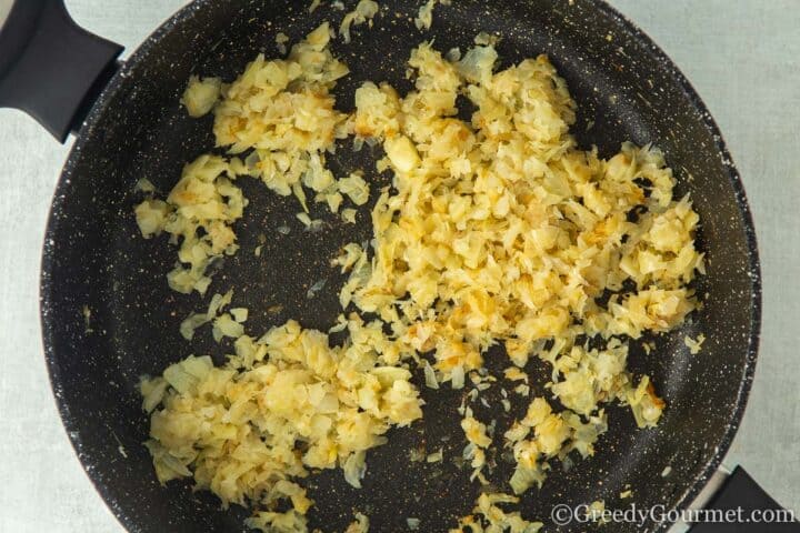 frying onion in a black pan.