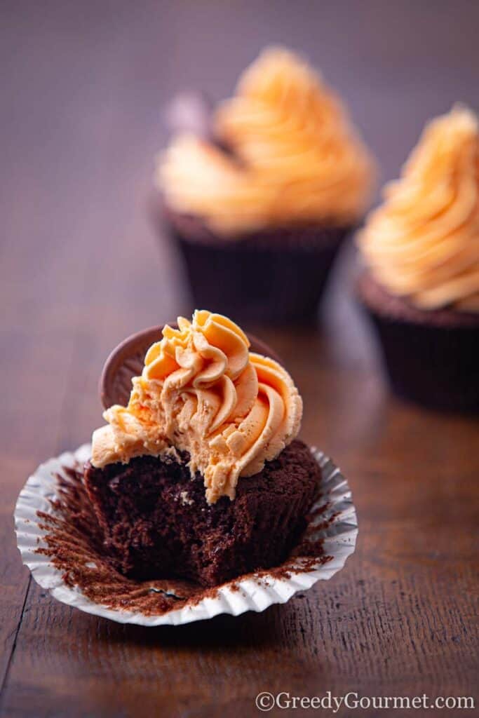 Chocolate orange cupcakes with bite missing.