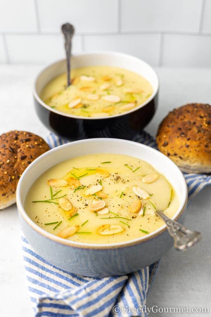 servings of soup with fresh bread and a spoon.