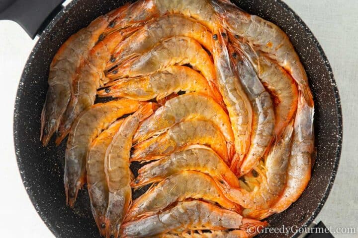 cooking shrimp in a pan with butter and garlic.