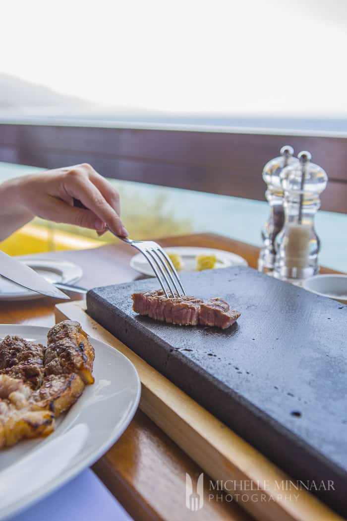 Steak being cooked at the dining table on a hot plate