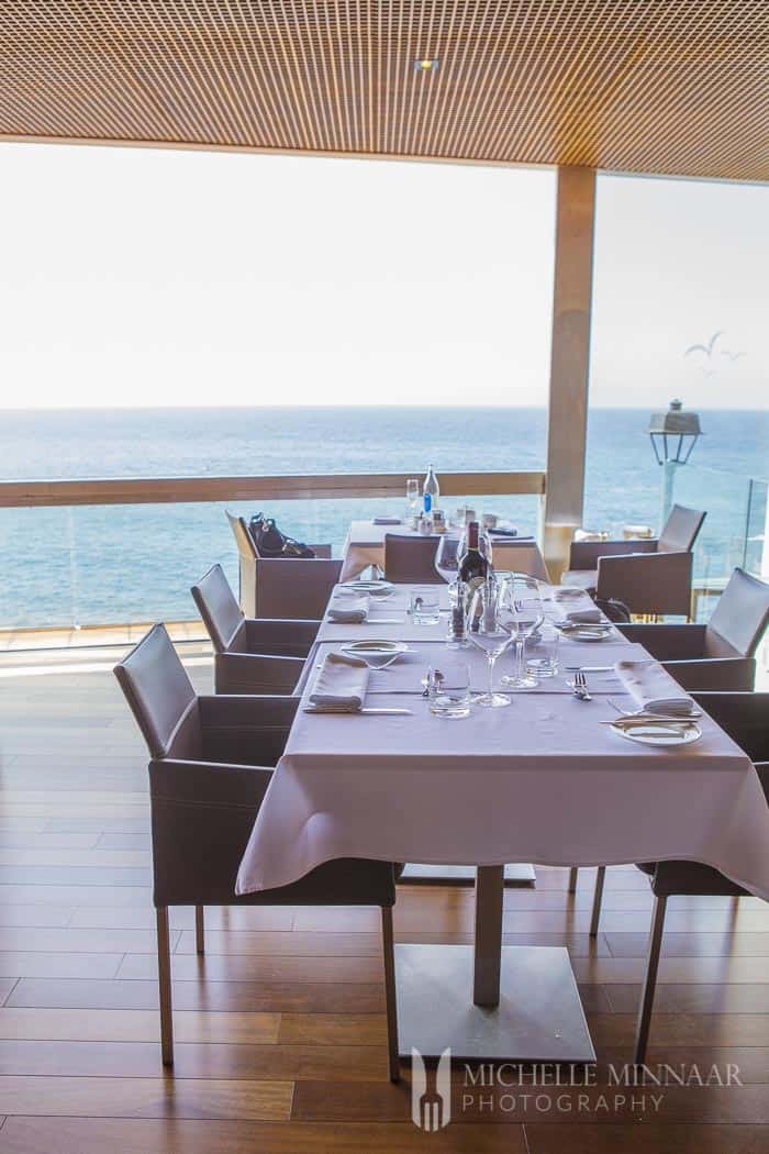 A long set dining table in Brunelli's Steakhouse with an ocean view