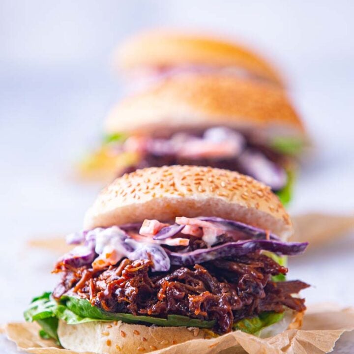 A pulled lamb slider on a seeded bun