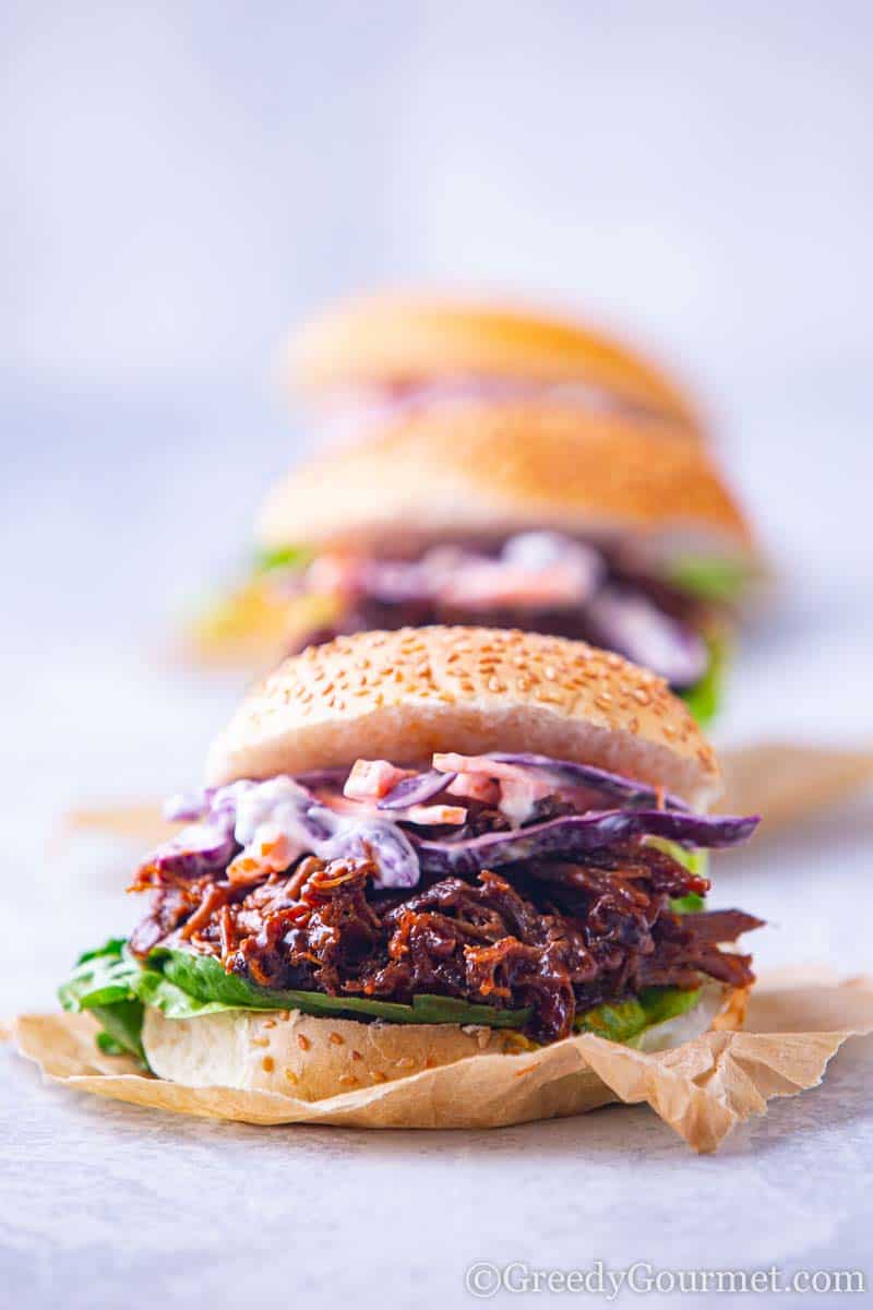 A pulled lamb slider on a seeded bun