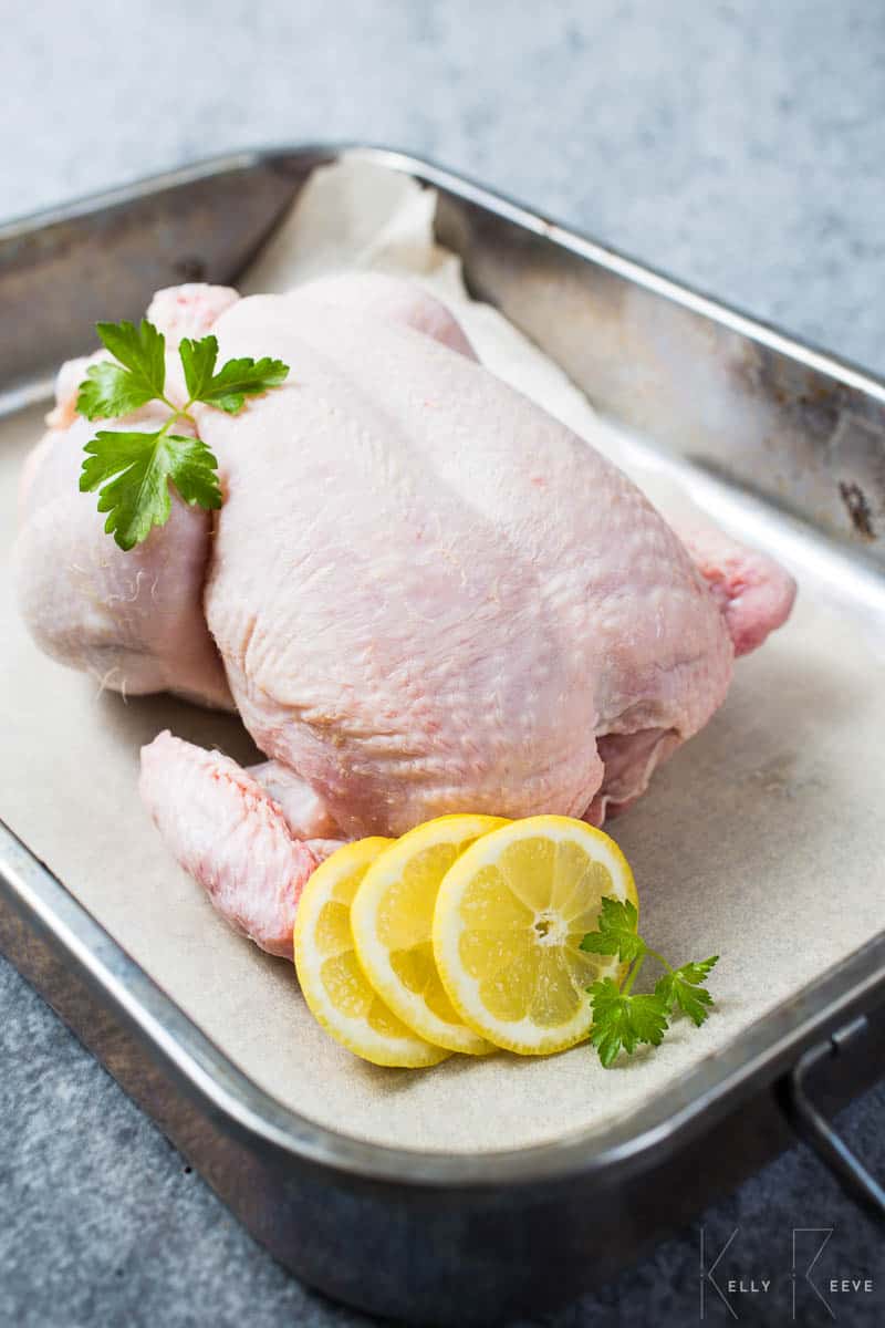Whole Chicken with a lemon in a pan 