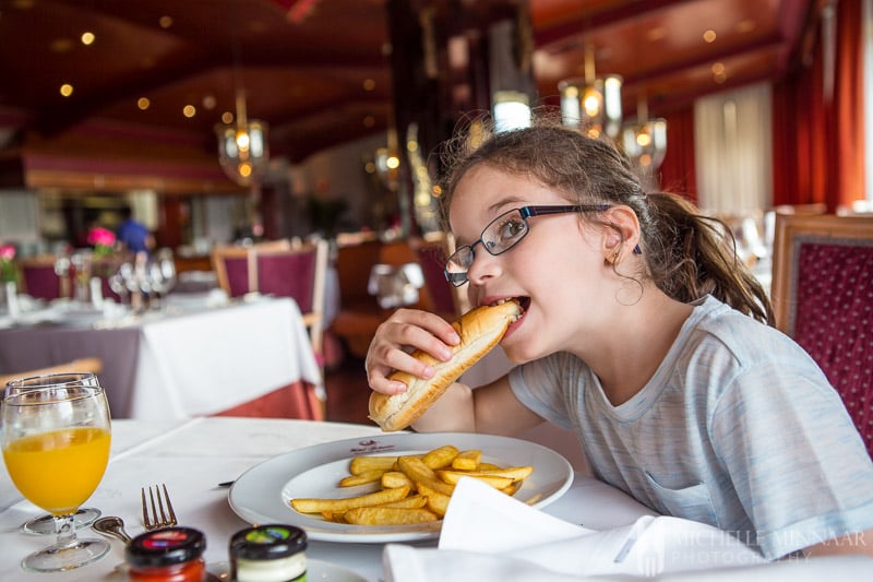Child eating hot dog with fries
