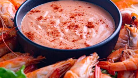 Fresh cocktail sauce and cooked prawns