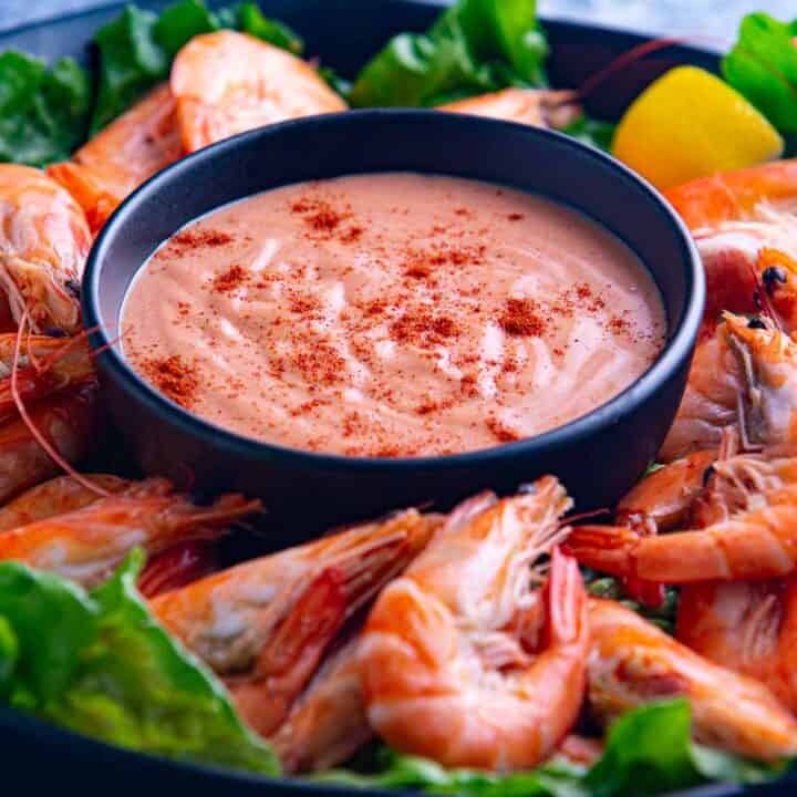 Fresh cocktail sauce and cooked prawns