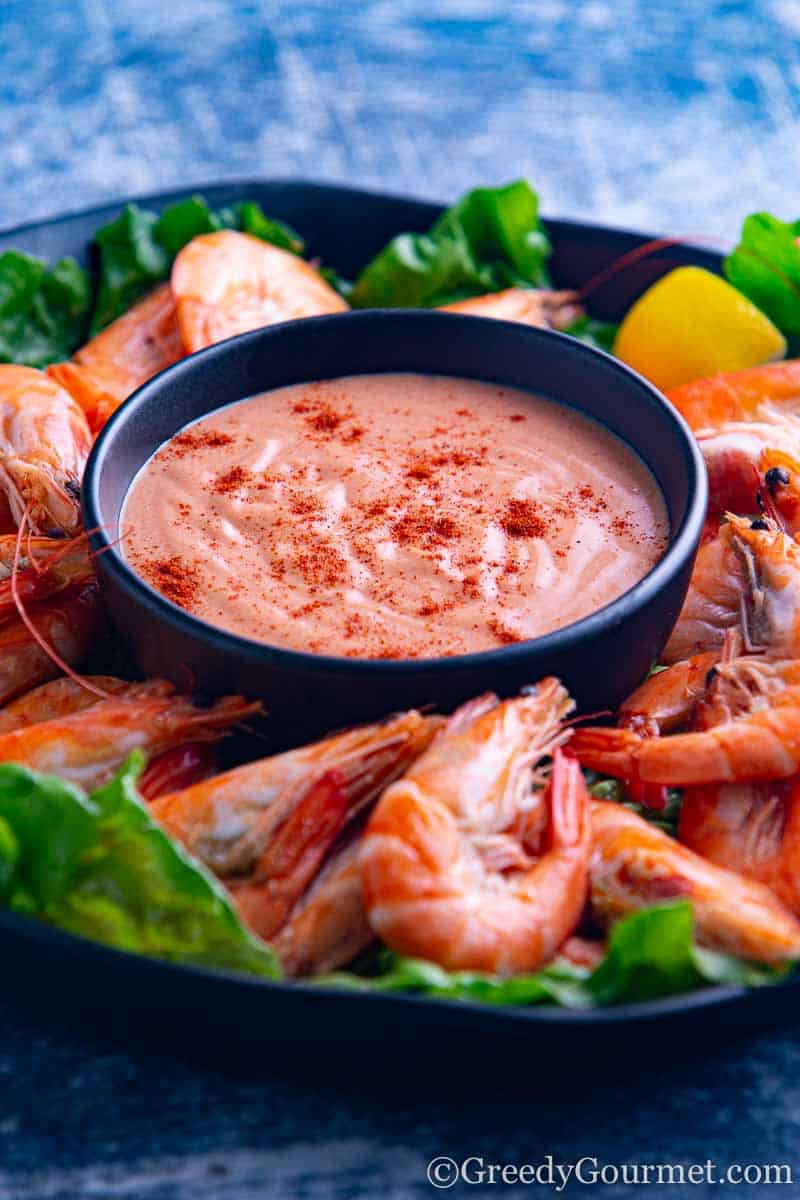 Fresh cocktail sauce and cooked prawns