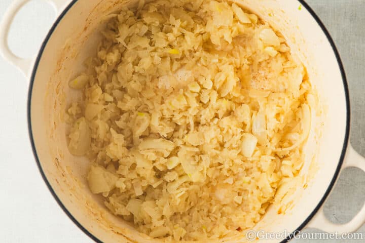 frying onions in a pot.