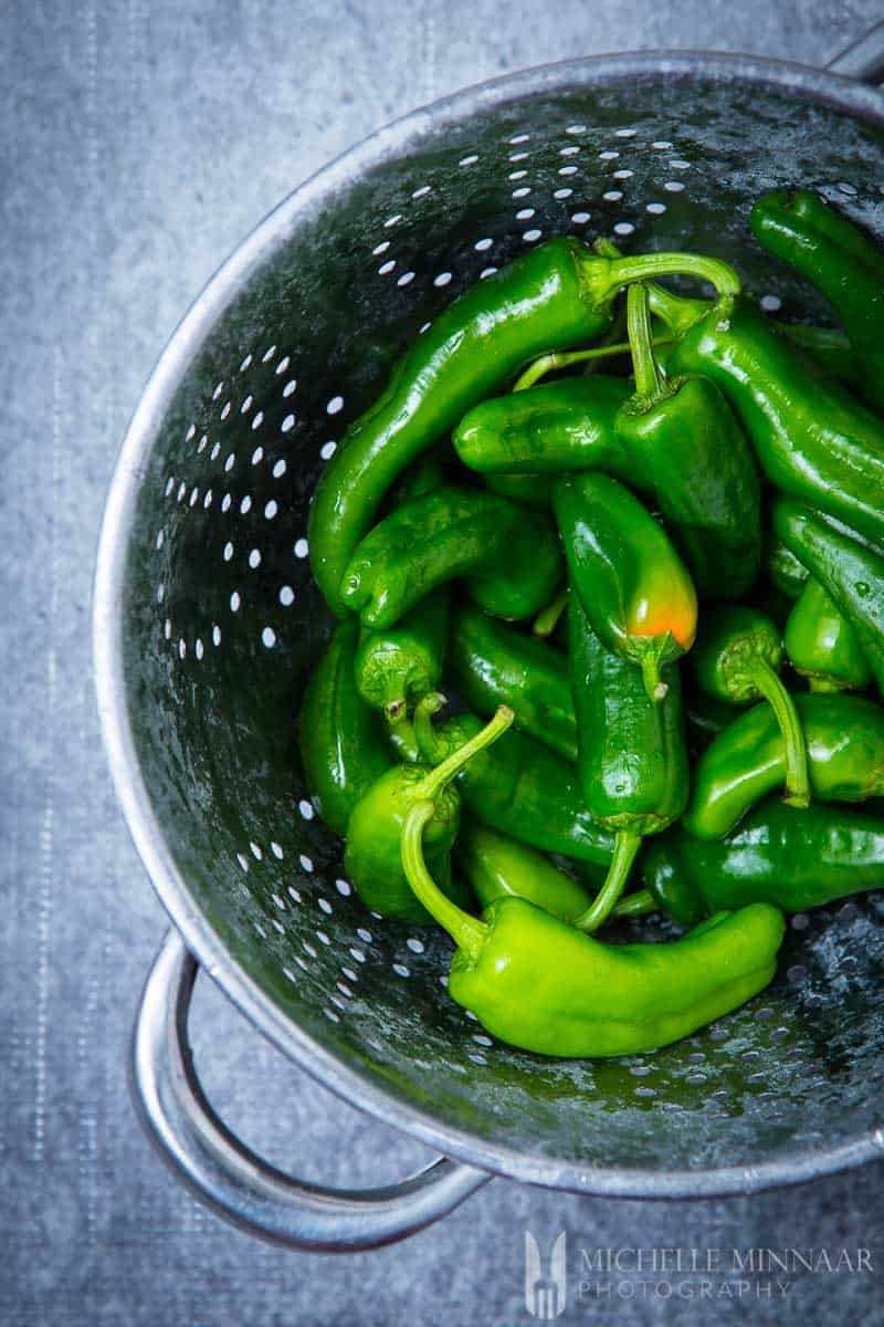 Green peppers in a strainer and washed