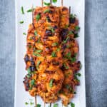 BBQ Chicken Kebabs on a white plate from far away