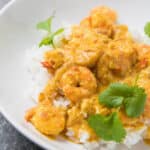 A close up view of prawns and rice in a white bowl