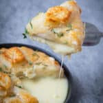 Camembert en Croute- slice of cheese being cut from the cheese wheel