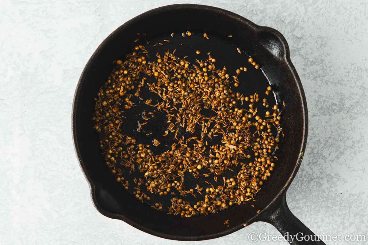 Dry roasting spices on a skillet.