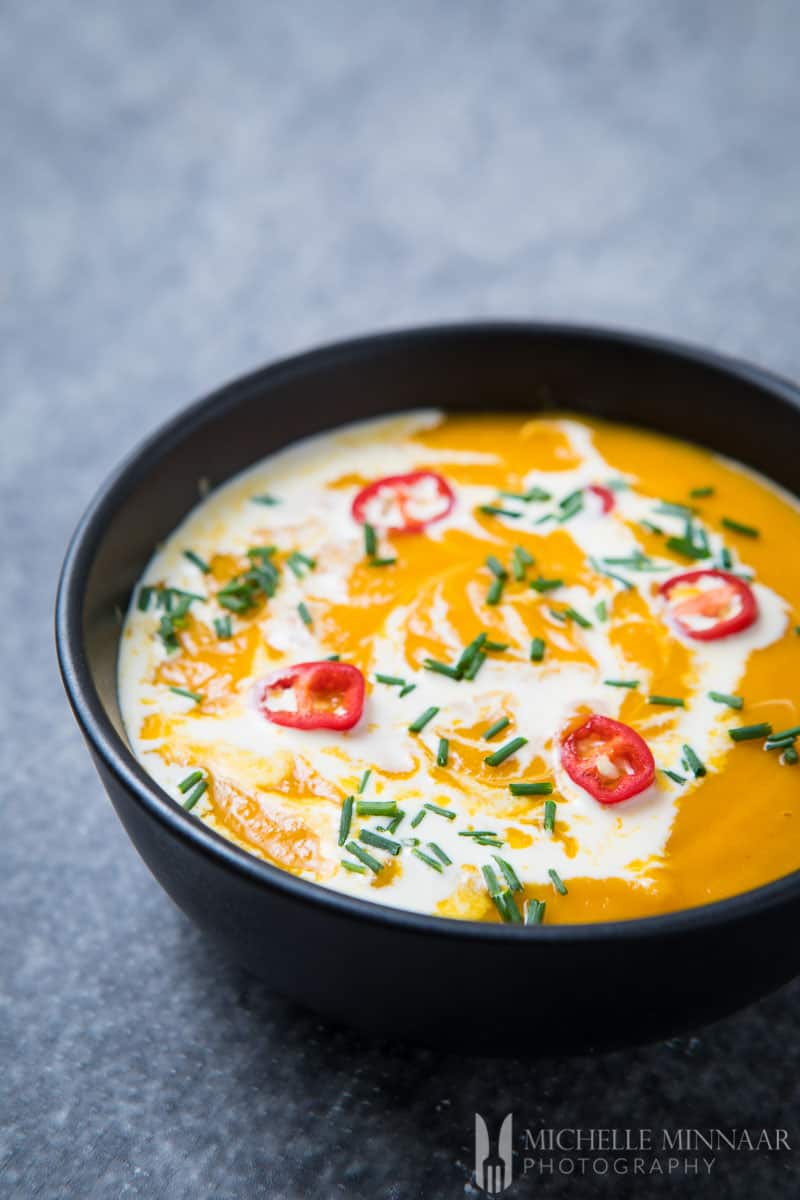 Slow Cooker Sweet Potato Soup - orange soup in a black bowl