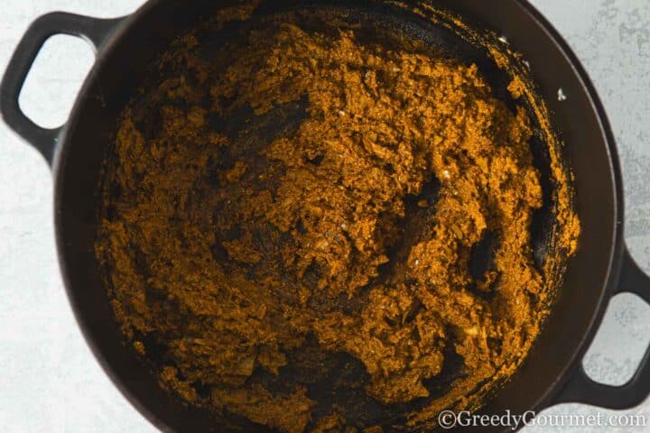 Fry korma curry paste in a pan.