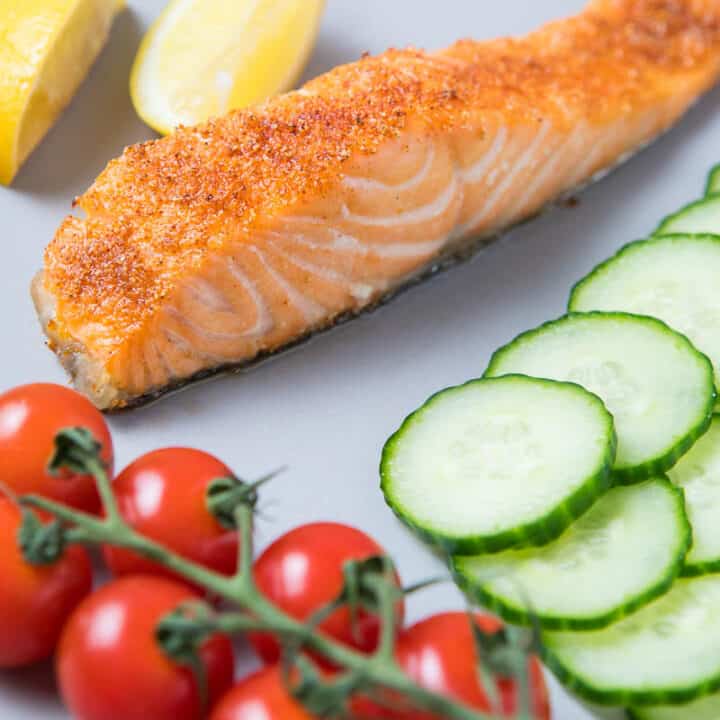 A piece of salmon, tomatoes, cucumbers and lemons for Air fried Salmon