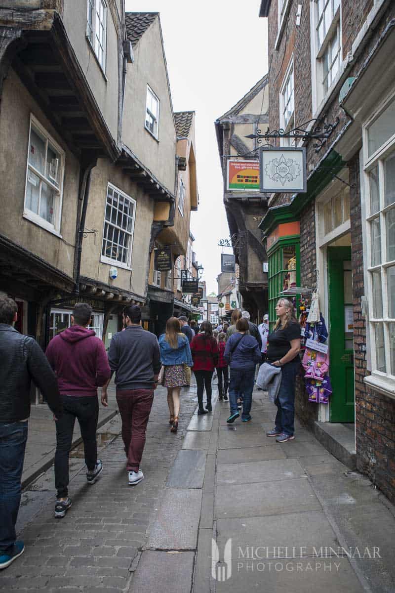 People walking down a narrow street
